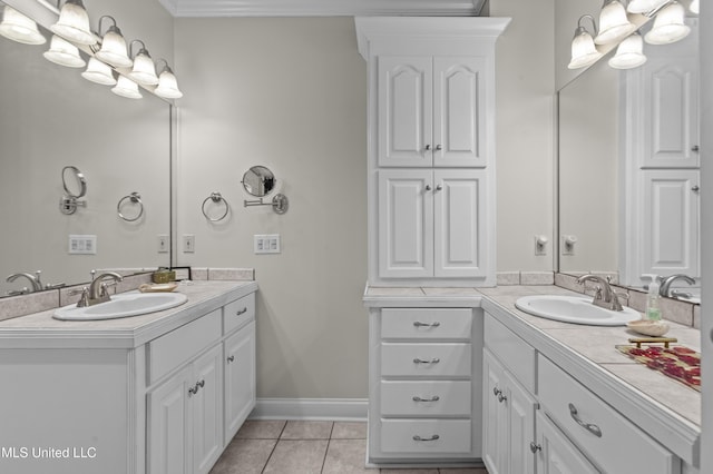 bathroom featuring tile patterned floors, two vanities, baseboards, and a sink