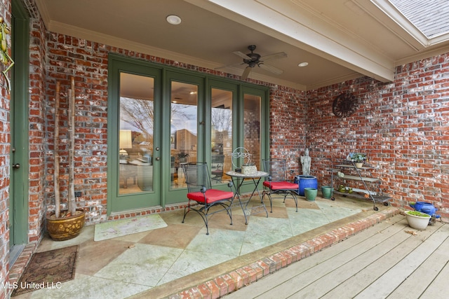 exterior space with french doors, brick siding, and ceiling fan