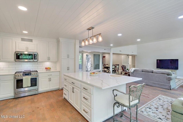 1844 Eastover Dr, Jackson, MS 39211 - kitchen featuring stainless steel appliances, white cabinetry, recessed lighting, a kitchen bar, and visible vents