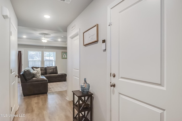 hallway featuring hardwood / wood-style flooring and crown molding