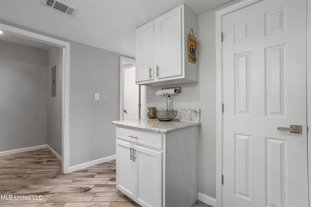 2869 Honduras Dr, Gautier, MS 39553 - kitchen featuring white cabinetry, light wood-style floors, electric panel, and light stone countertops