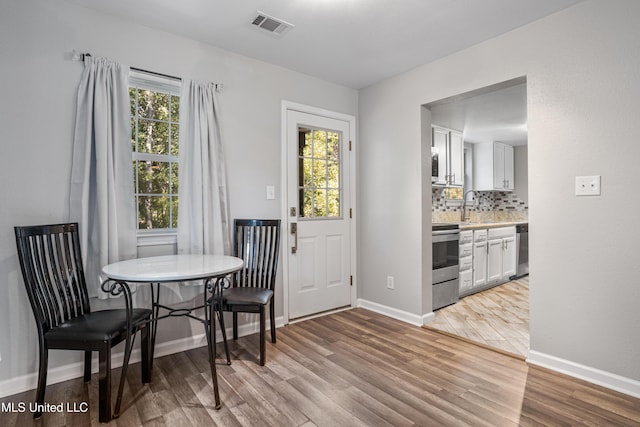 dining room with light hardwood / wood-style floors and sink