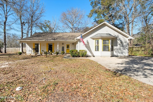 single story home with covered porch and fence