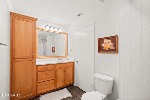 bathroom with tile patterned flooring, toilet, vanity, and visible vents