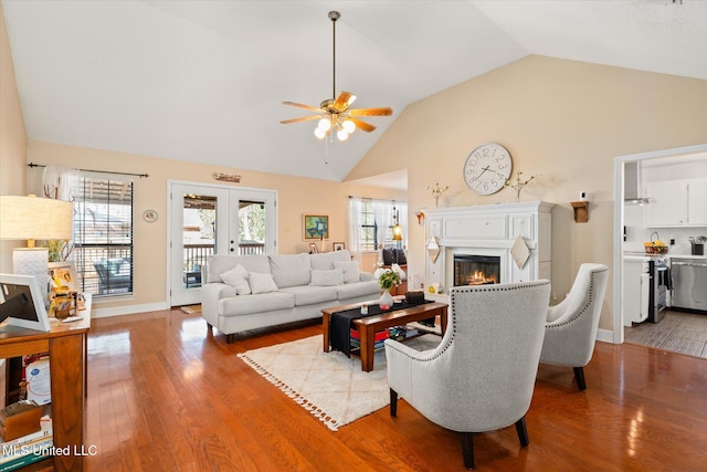 living room with a glass covered fireplace, a healthy amount of sunlight, and wood finished floors