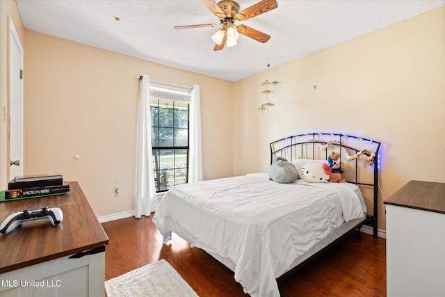 bedroom featuring a ceiling fan, baseboards, dark wood-style flooring, and a textured ceiling