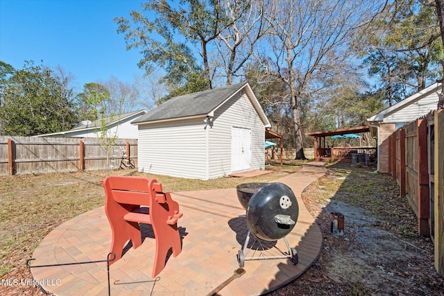 view of patio / terrace featuring an outbuilding, central air condition unit, and a fenced backyard