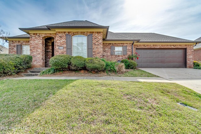 ranch-style house featuring a garage, brick siding, a front lawn, roof with shingles, and driveway