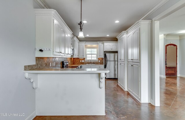kitchen featuring decorative backsplash, light countertops, a peninsula, stainless steel appliances, and a sink
