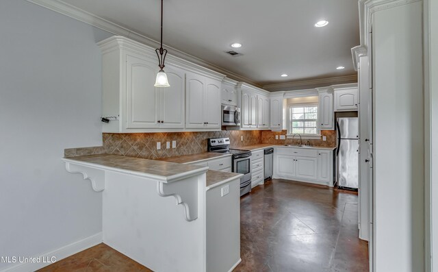kitchen with a sink, a kitchen breakfast bar, a peninsula, stainless steel appliances, and visible vents