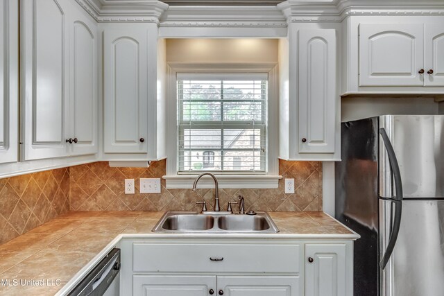 kitchen featuring white cabinets, a sink, tasteful backsplash, and appliances with stainless steel finishes