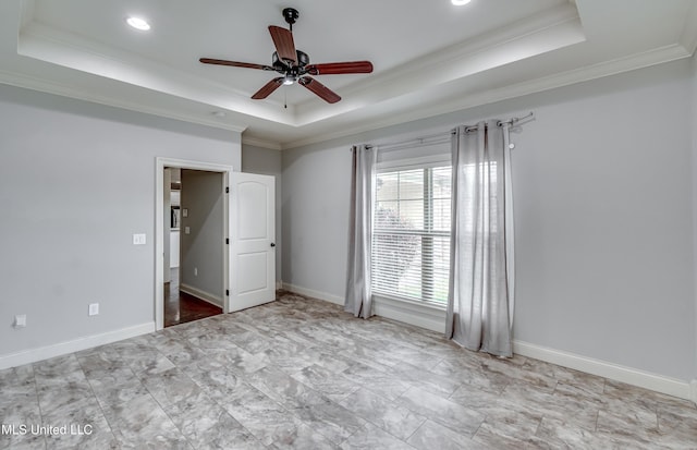 unfurnished bedroom with baseboards, a ceiling fan, ornamental molding, and a raised ceiling