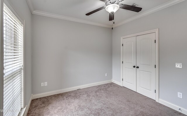 unfurnished bedroom featuring a closet, visible vents, crown molding, carpet, and baseboards