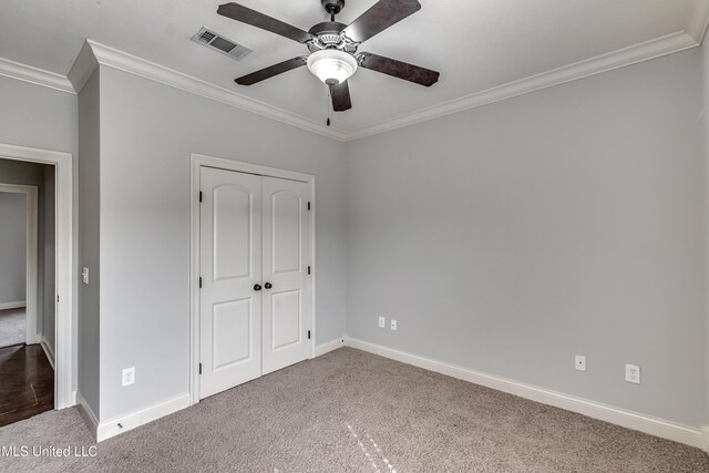 unfurnished bedroom featuring carpet floors, ornamental molding, baseboards, and visible vents