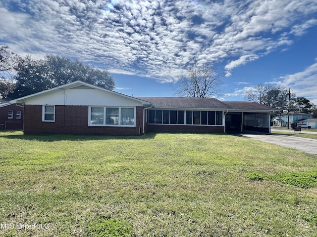 ranch-style house featuring a carport, concrete driveway, brick siding, and a front lawn