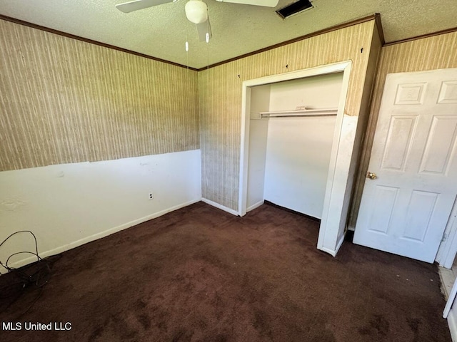208 Cedar Dr, Diberville, MS 39540 - unfurnished bedroom featuring crown molding, dark colored carpet, a closet, a textured ceiling, and ceiling fan