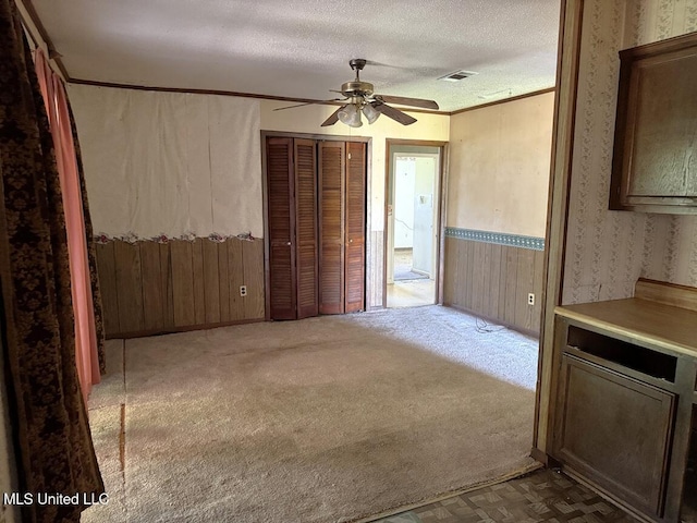 208 Cedar Dr, Diberville, MS 39540 - interior space with wallpapered walls, ceiling fan, and a textured ceiling