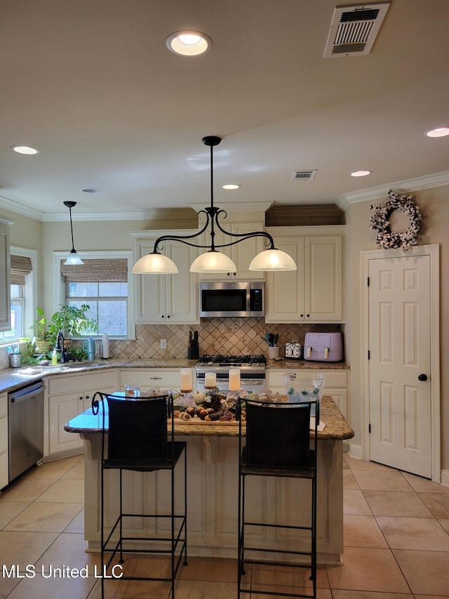 kitchen featuring hanging light fixtures, a center island, a kitchen bar, and stainless steel appliances