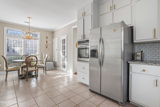 kitchen featuring white cabinetry, stainless steel appliances, backsplash, and light tile patterned floors