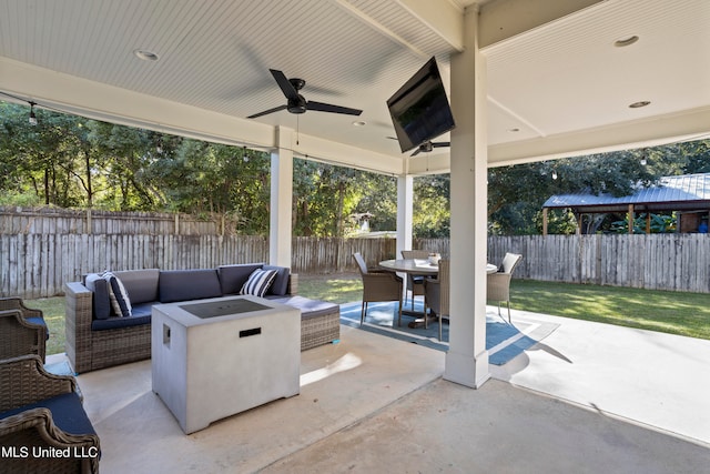 view of patio with ceiling fan and an outdoor living space with a fire pit