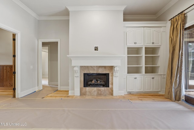 unfurnished living room featuring baseboards, ornamental molding, and a tile fireplace