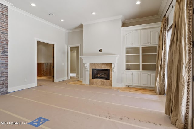 unfurnished living room with a premium fireplace, visible vents, baseboards, ornamental molding, and recessed lighting