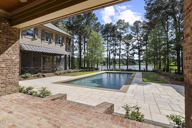 view of pool featuring a sunroom, a water view, a patio, and a fenced in pool
