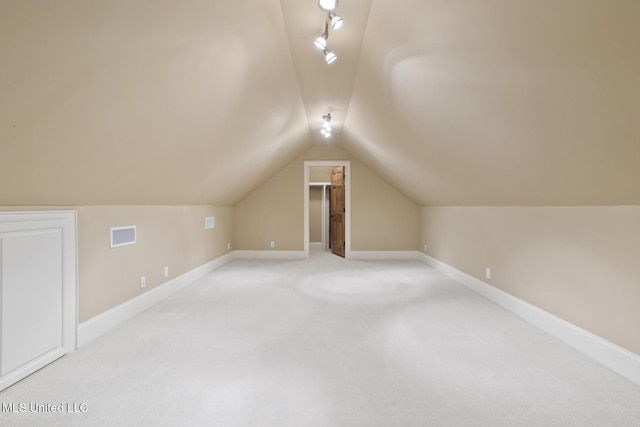 bonus room with lofted ceiling, light carpet, visible vents, and baseboards