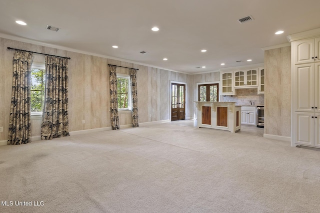 unfurnished living room featuring light colored carpet, crown molding, visible vents, and recessed lighting