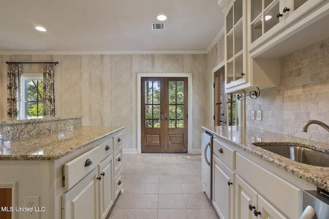 kitchen featuring plenty of natural light, french doors, visible vents, and a sink