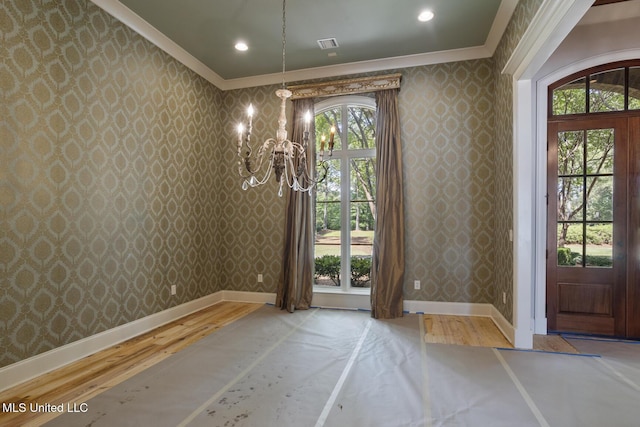 unfurnished dining area featuring wallpapered walls and crown molding