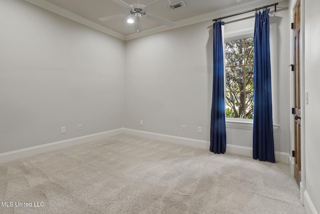 carpeted spare room with baseboards, a ceiling fan, visible vents, and plenty of natural light