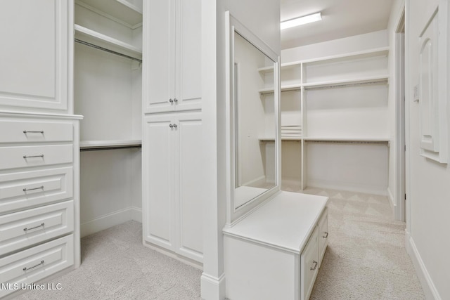 walk in closet featuring light carpet