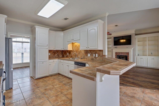 kitchen with ornamental molding, appliances with stainless steel finishes, white cabinets, and kitchen peninsula