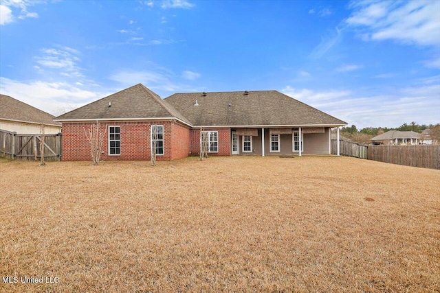 rear view of property featuring a yard