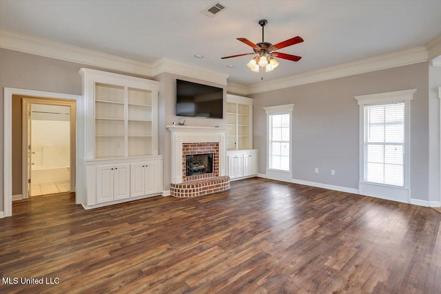 unfurnished living room with ornamental molding, a brick fireplace, dark wood-type flooring, and ceiling fan