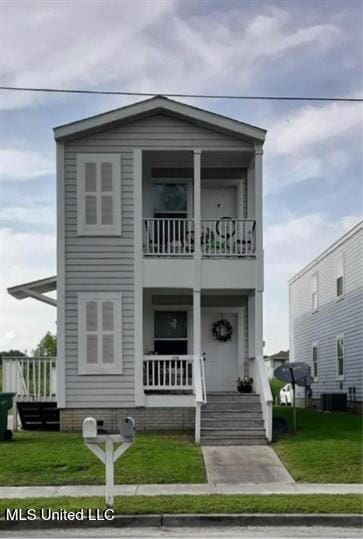 view of front of property featuring a porch, a balcony, and a front lawn