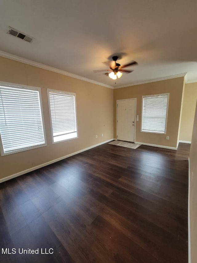 spare room featuring crown molding, a ceiling fan, dark wood finished floors, and baseboards