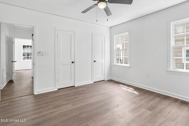 unfurnished bedroom with dark wood-type flooring and ceiling fan