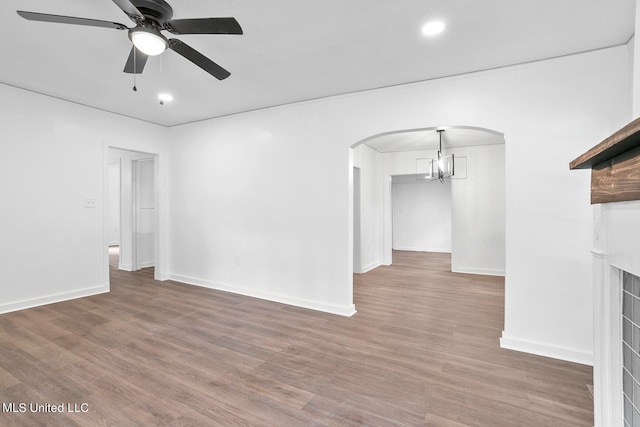 unfurnished living room with dark hardwood / wood-style flooring and ceiling fan with notable chandelier