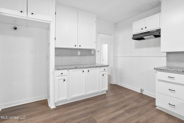 kitchen featuring white cabinets, light stone countertops, tasteful backsplash, and dark hardwood / wood-style floors