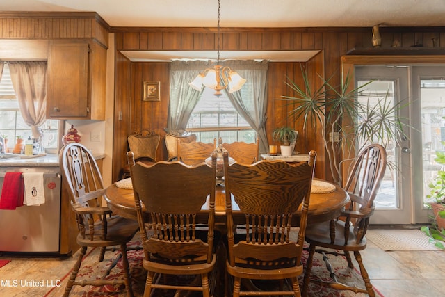 dining room featuring wooden walls and a chandelier