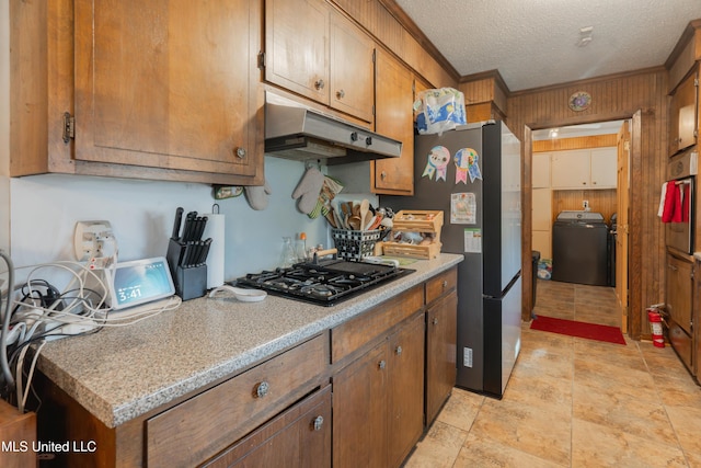 kitchen with crown molding, appliances with stainless steel finishes, washer / dryer, and a textured ceiling