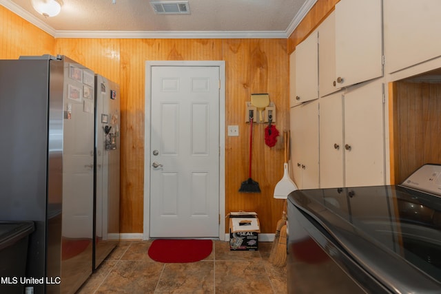 interior space with wooden walls, ornamental molding, washer / clothes dryer, and a textured ceiling