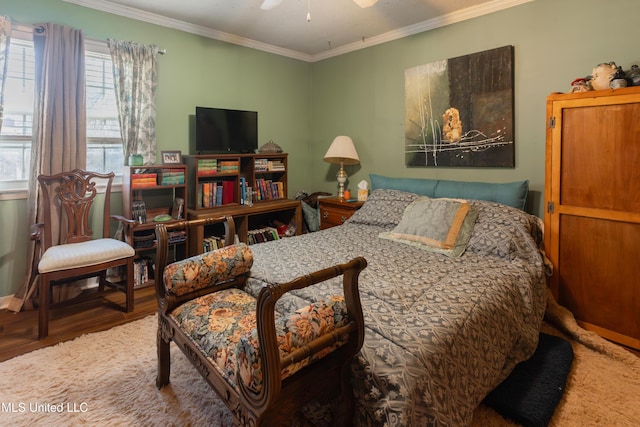 bedroom featuring crown molding, wood-type flooring, and ceiling fan