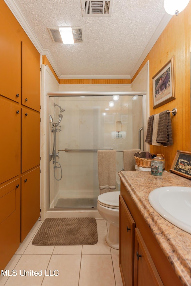 bathroom with crown molding, tile patterned floors, a shower with shower door, and vanity