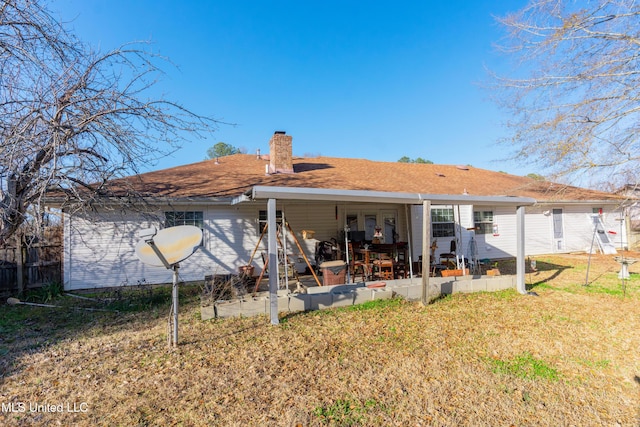 rear view of house featuring a patio area and a lawn