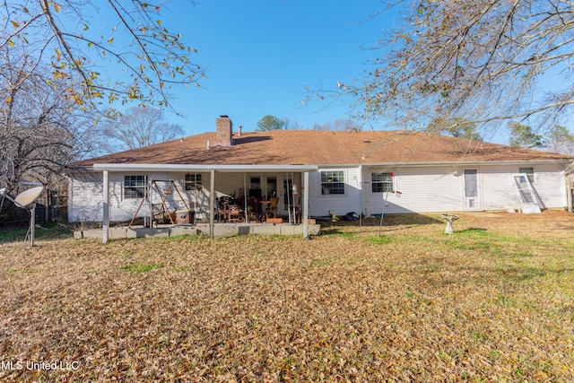 rear view of property featuring a lawn