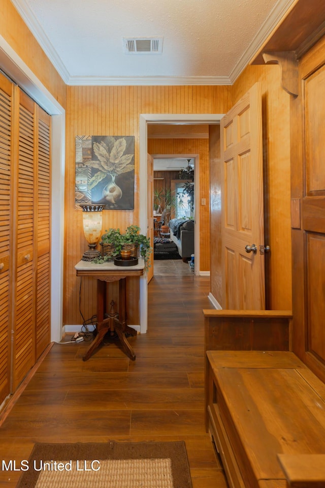 corridor featuring ornamental molding and dark wood-type flooring