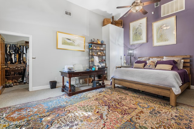 carpeted bedroom with a spacious closet, ceiling fan, a closet, and vaulted ceiling